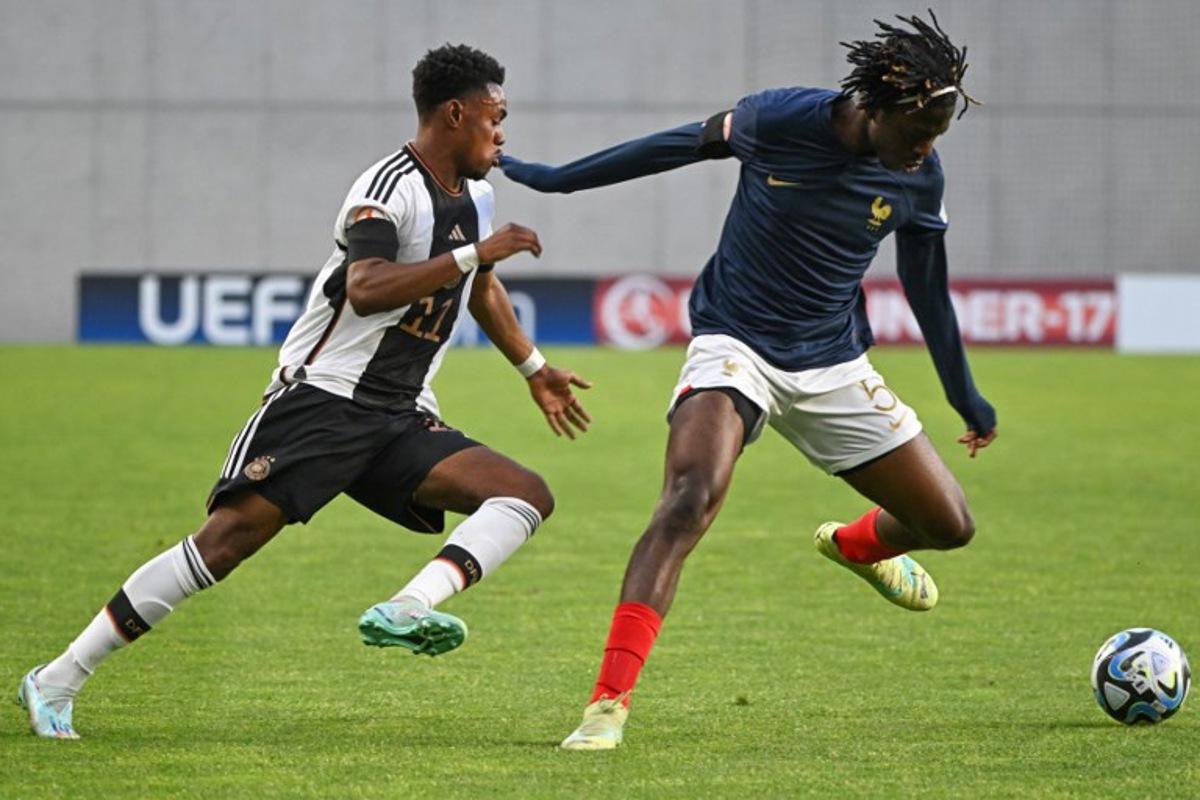 Germany's midfielder Charles Herrmann (L) and France's defender Bastien Meupiyou vie for the ball during the UEFA Under 17 final football match between Germany and France at the Hidegkuti Nandor Stadium in Budapest, Hungary on June 2, 2023. Attila KISBENEDEK / AFP