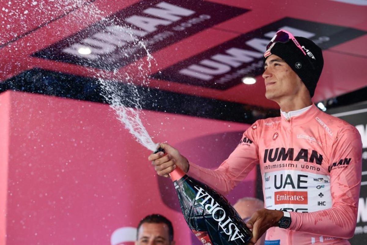UAE Team Emirates XRG's Mexican rider Isaac Del Toro wearing the pink jersey of overall leader (Maglia Rosa) sprays champagne as he celebrates on the podium after placed second in the 19th stage of the 108th Giro d'Italia cycling race of 166kms from Biella to Champoluc on May 30, 2025. Luca Bettini / AFP
