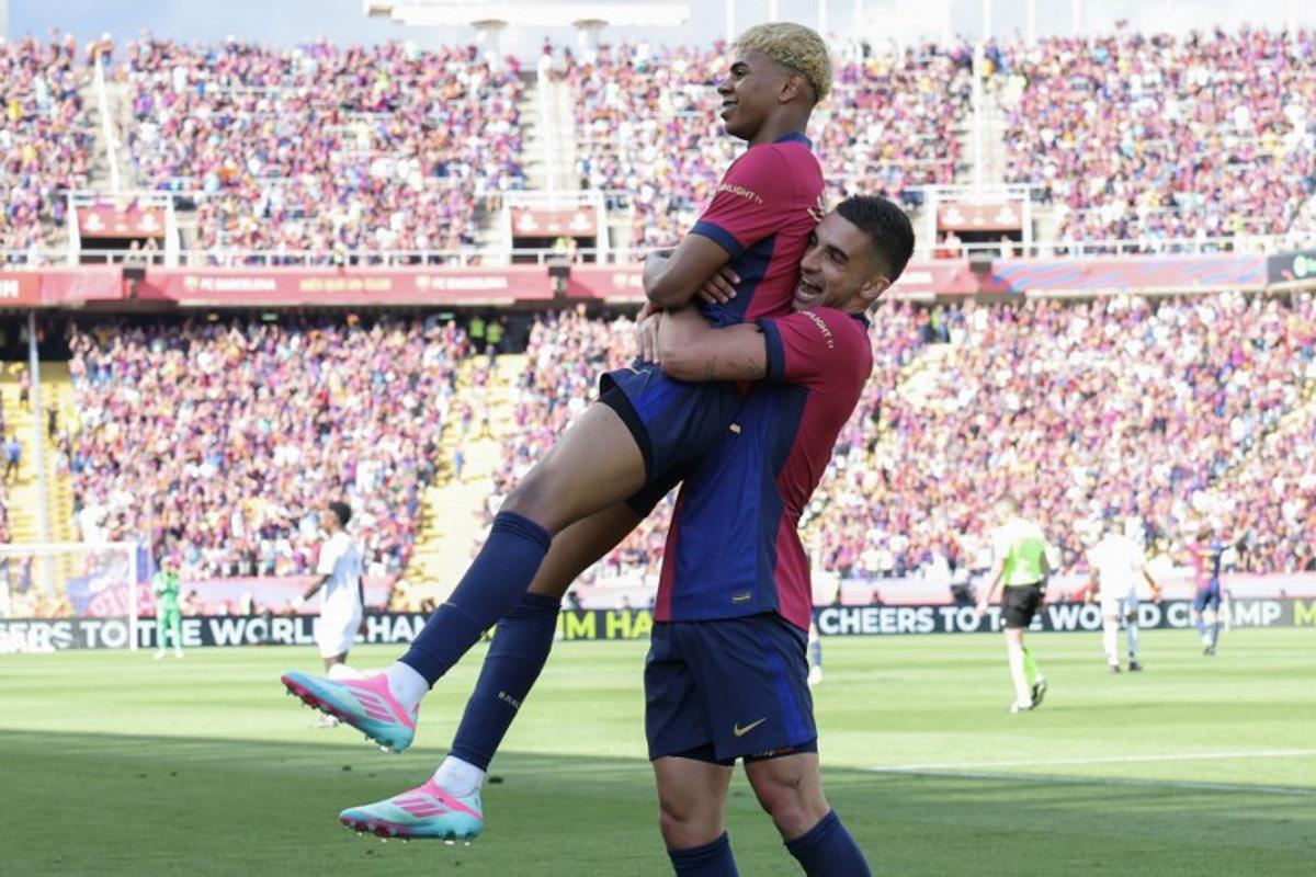 Barcelona's Spanish forward #19 Lamine Yamal celebrates scoring his team's second goal with Barcelona's Spanish forward #07 Ferran Torres during the Spanish league football match between FC Barcelona and Real Madrid CF at Estadi Olimpic Lluis Companys in Barcelona, on May 11, 2025. LLUIS GENE / AFP