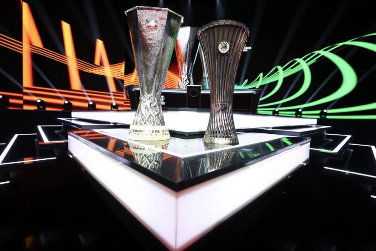 This photograph taken on August 28, 2026 shows the Europa League trophy (L) and Conference League trophy (R) during the draw ceremony for the league phase of the 2026-2027 UEFA Europa and Conference League football tournaments at the Grimaldi Forum in the Principality of Monaco. Valery HACHE / AFP