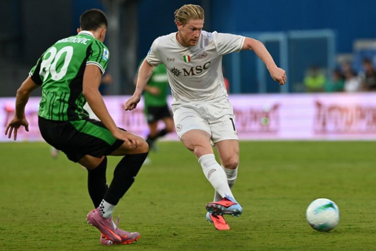 Napoli's Belgian midfielder #11 Kevin De Bruyne fights for the ball with Sassuolo's Bosnian defender #80 Tarik Muharemovic during the Italian Serie A football match between Sassuolo and Napoli at the Mapei - Città del Tricolore stadium in Reggio Emilia, on August 23, 2025. Stefano RELLANDINI / AFP