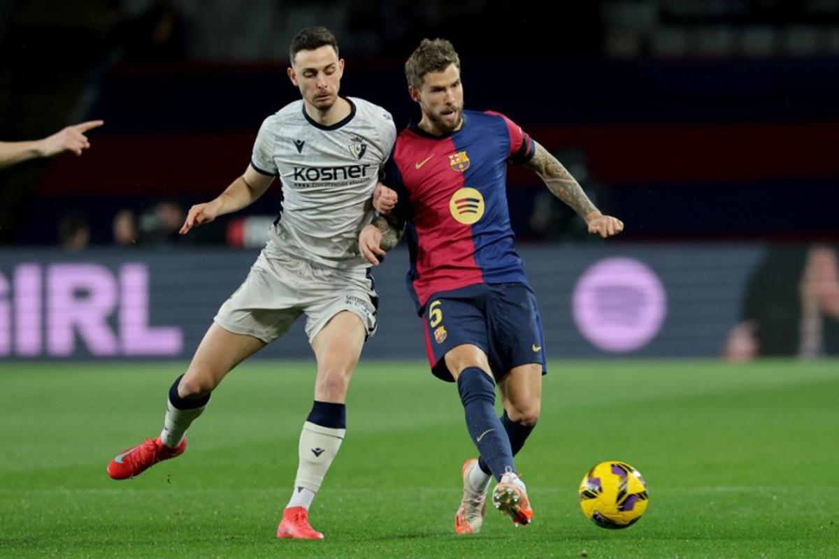 Osasuna's Spanish forward #09 Raul Garcia and Barcelona's Spanish defender #05 Inigo Martinez Berridi fight for the ball during the Spanish league football match between FC Barcelona and CA Osasuna at Estadi Olimpic Lluis Companys in Barcelona on March 27, 2025. LLUIS GENE / AFP