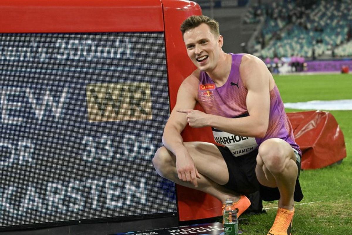 Norway's Karsten Warholm poses with his time of 33.05 seconds after he broke the men's 300m hurdles world record during the Xiamen IAAF Diamond League athletics meeting at Egret Stadium in Xiamen, in China's eastern Fujian province, on April 26, 2025. ADEK BERRY / AFP
