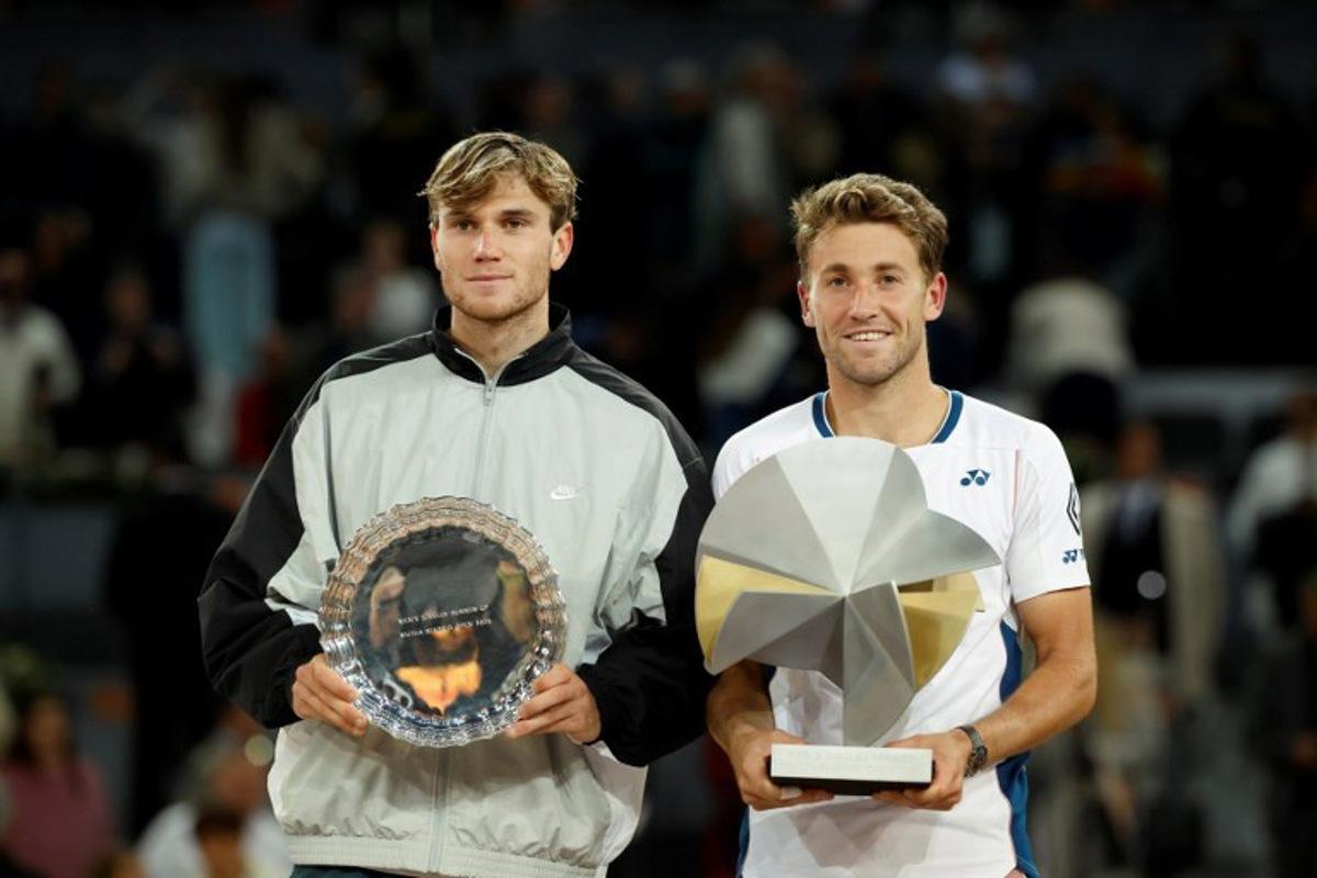 Winner Norway's Casper Ruud (R) and Britain's Jack Draper pose with their trophies at the end of their 2025 ATP Tour Madrid Open tennis tournament singles final match at the Caja Magica in Madrid, on May 4, 2025. OSCAR DEL POZO / AFP