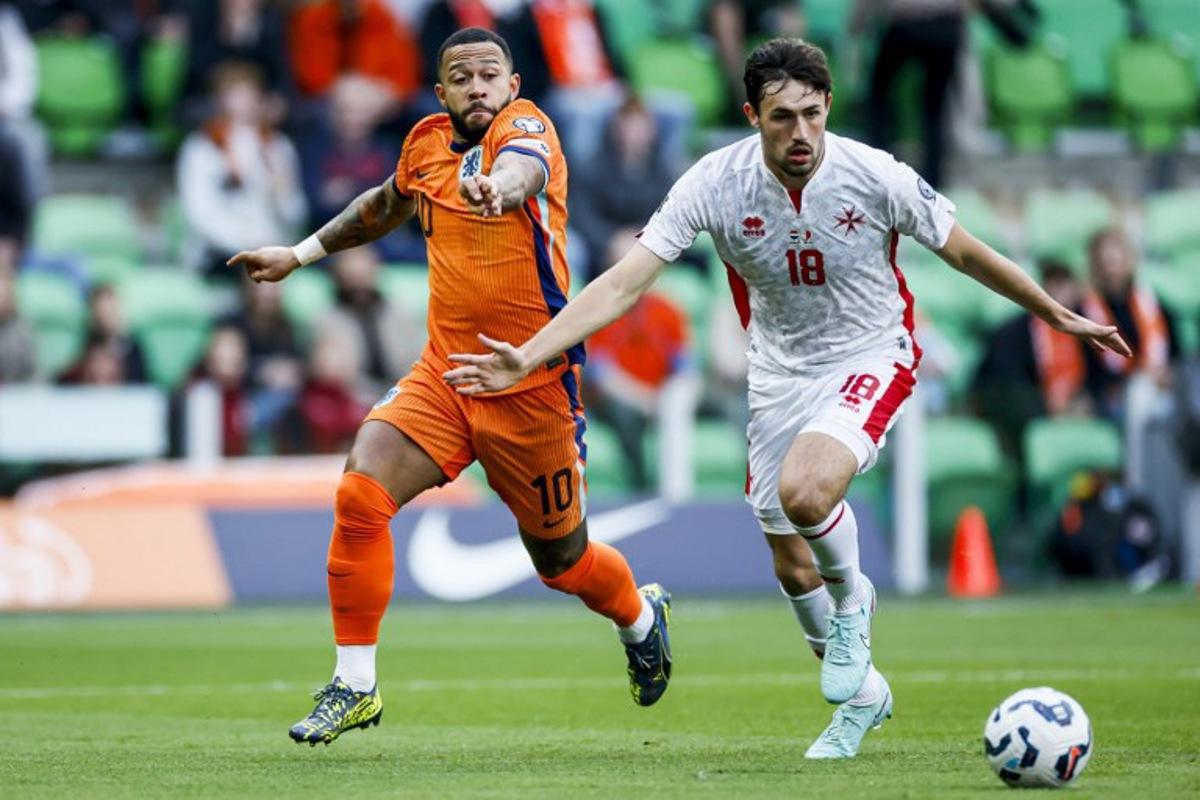 Memphis Depay of the Netherlands (L) fights for the ball with James Carragher of Malta during the World Cup qualifier between the Netherlands and Malta at the Euroborg stadium in Groningen on June 10, 2025. Koen Van WEEL / ANP / AFP
