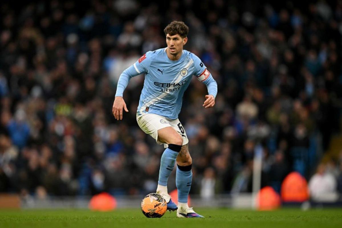 Manchester City's English defender #05 John Stones runs with the ball during the English FA Cup third round football match between Manchester City and Salford City at the Etihad Stadium in Manchester, north west England, on February 14, 2026. Oli SCARFF / AFP