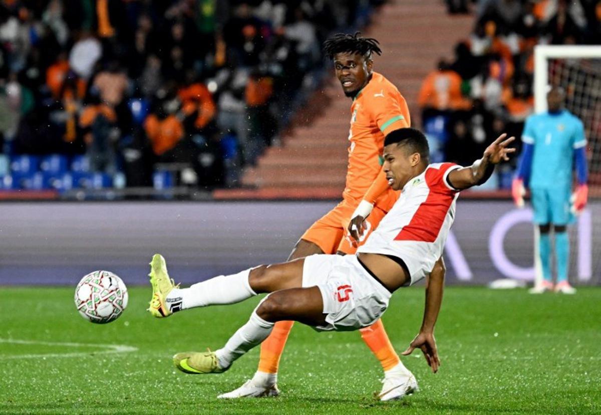 Ivory Coast's forward #10 Wilfried Zaha (L) is tackled by Mozambique's defender #15 Reinildo Mandava during the Africa Cup of Nations (CAN) Group F football match between Ivory Coast and Mozambique at Marrakesh Stadium in Marrakesh on December 24, 2025. Khaled DESOUKI / AFP
