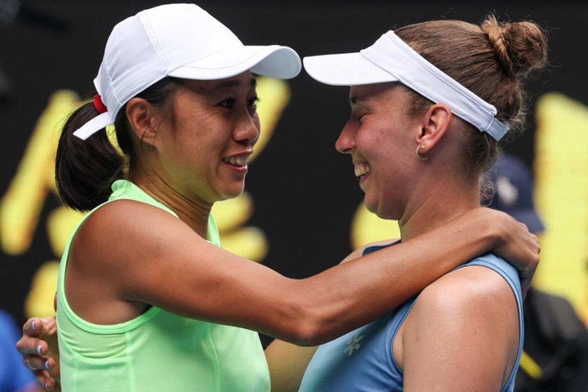 China's Zhang Shuai (L) celebrates with partner Belgium's Elise Mertens after their victory in their women's doubles final match against Kazakhstan's Anna Danilina and Serbia's Aleksandra Krunic on day fourteen of the Australian Open tennis tournament in Melbourne on January 31, 2026. DAVID GRAY / AFP