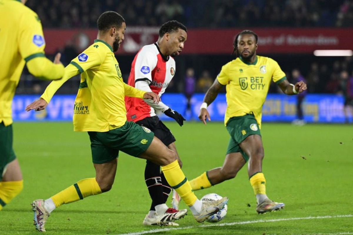 Fortuna Sittard's Belgian defender #04 Shawn Adewoye (L) fights for the ball with Feyenoord's Dutch midfielder #08 Quinten Timber (C) during the Dutch Eredivisie football match between Feyenoord and Fortuna Sittard at De Kuip Stadium in Rotterdam on November 30, 2024. Olaf Kraak / ANP / AFP