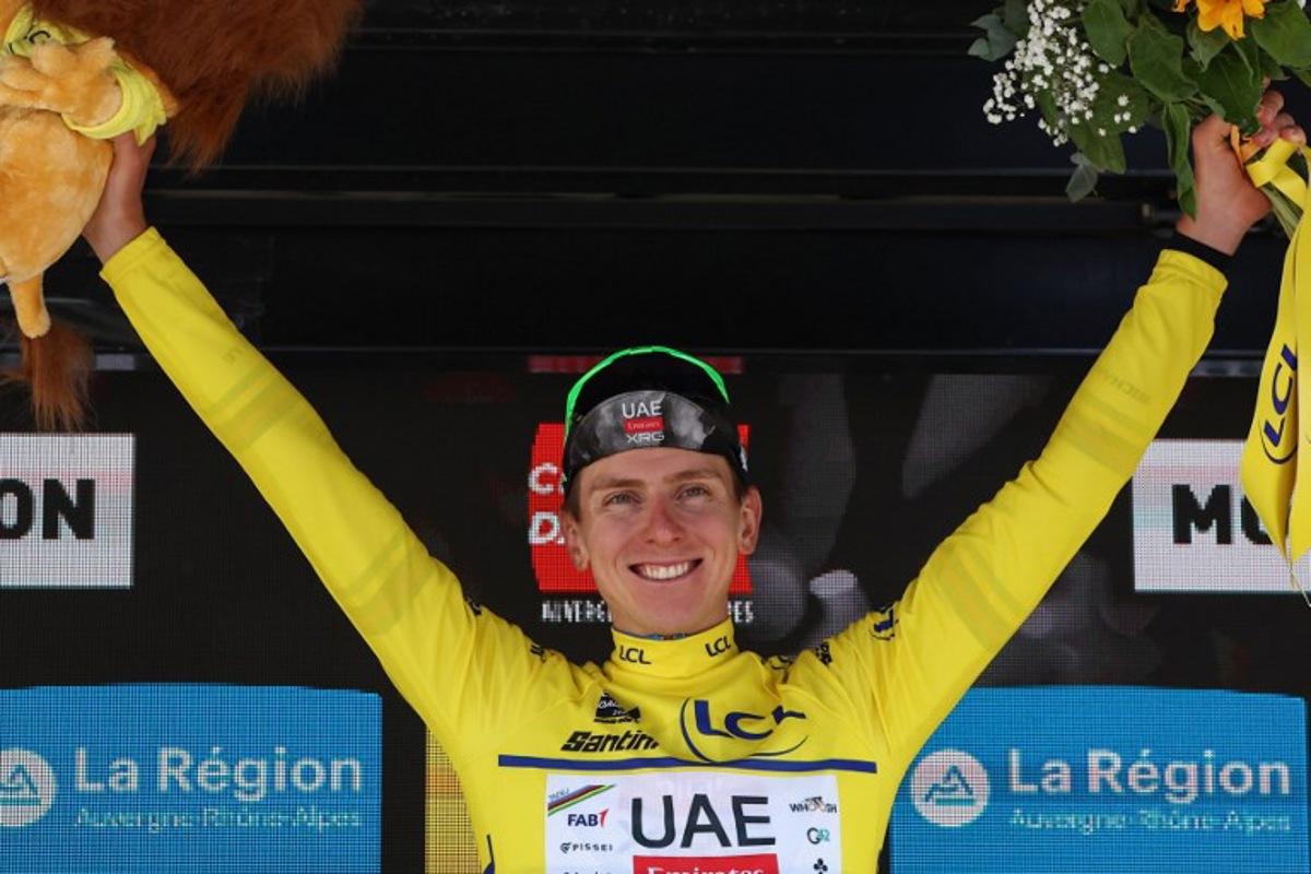UAE Team Emirates XRG's Slovenian rider Tadej Pogačar celebrates wearing the overall leader's yellow jersey on the podium of the 1st stage of the 77th edition of the Criterium du Dauphine cycling race, 195,8 km between Domérat and Montlucon, on June 8, 2025. Anne-Christine POUJOULAT / AFP