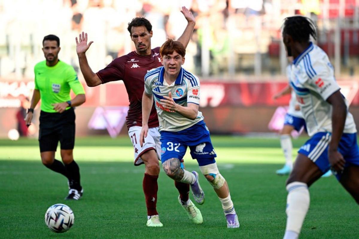 Metz's French midfielder #21 Benjamin Stambouli fights for the ball with Strasbourg's Argentine defender #32 Valentin Barco (C) during the French L1 football match between Metz and Srasbourg at Stade Saint-Symphorien in Metz on August 17, 2025. Jean-Christophe VERHAEGEN / AFP