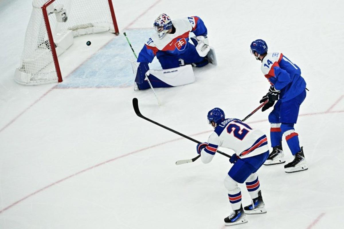 USA's #21 Dylan Larkin (L) scores their first goal past Slovakia's #31 Samuel Hlavaj during the men's play-off semi-final ice hockey match between USA and Slovakia at the Milano Santagiulia Ice Hockey Arena during the Milano Cortina 2026 Winter Olympic Games in Milan, on February 20, 2026. JULIEN DE ROSA / AFP