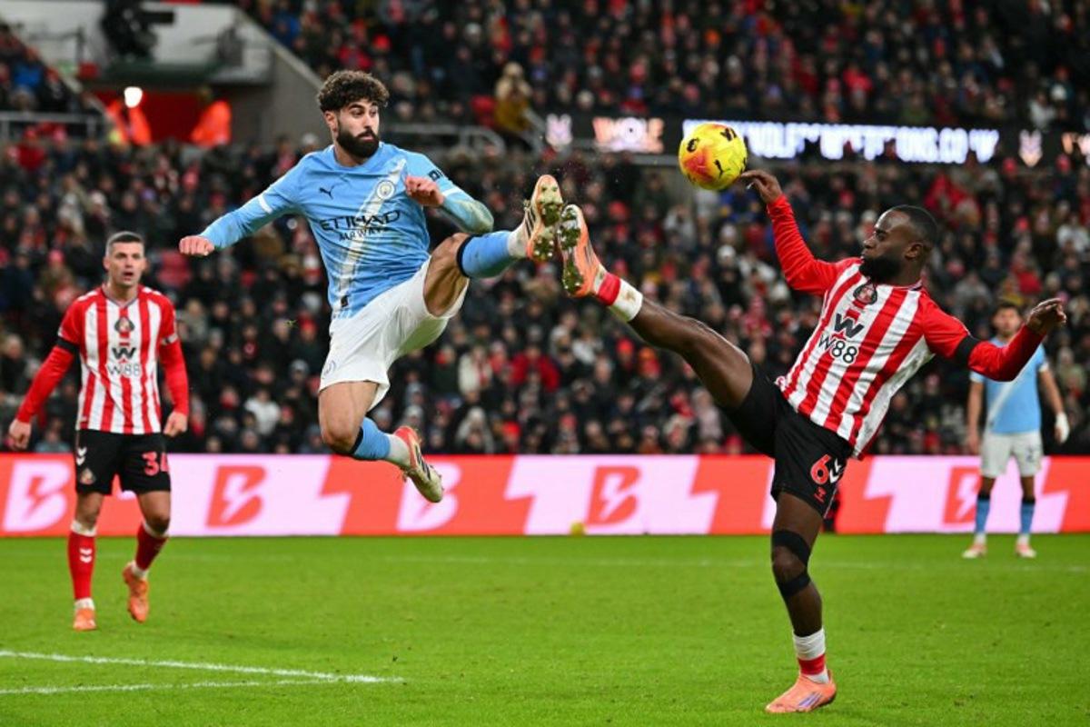 Manchester City's Croatian defender #24 Josko Gvardiol (C) leaps for a ball against Sunderland's Dutch defender #06 Lutsharel Geertruida (R) during the English Premier League football match between Sunderland and Manchester City at The Stadium of Light in Sunderland in north east England on January 1, 2026. ANDY BUCHANAN / AFP