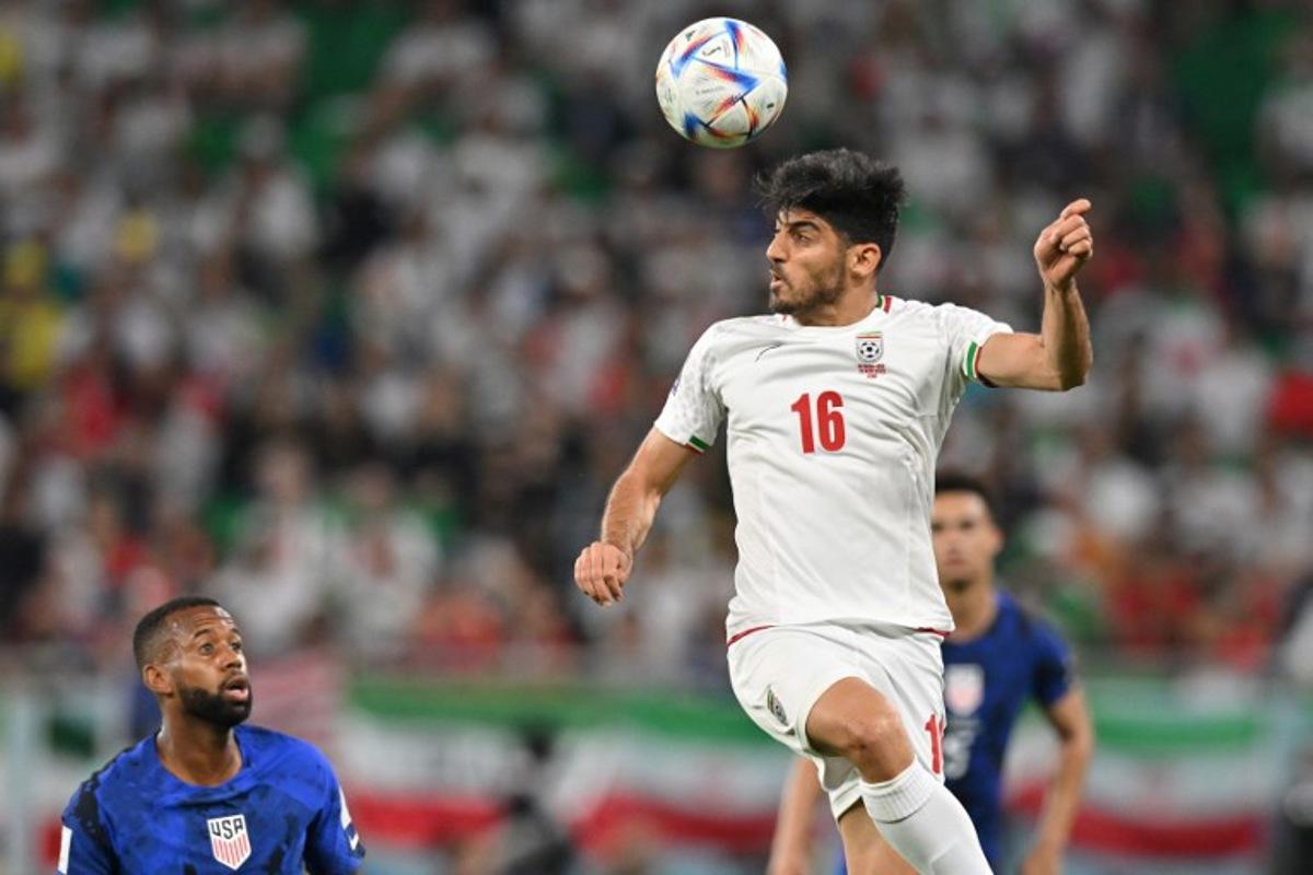 Iran's midfielder #16 Mehdi Torabi heads the ball during the Qatar 2022 World Cup Group B football match between Iran and USA at the Al-Thumama Stadium in Doha on November 29, 2022. Glyn KIRK / AFP