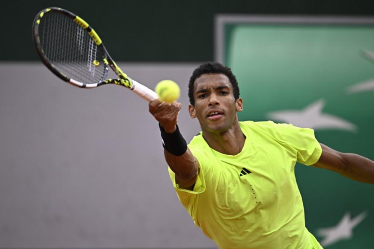 Canada's Felix Auger-Aliassime plays a backhand return to Italia's Matteo Arnaldi during their men's singles match on day 3 of the French Open tennis tournament at the Roland-Garros Complex in Paris on May 27, 2025. JULIEN DE ROSA / AFP