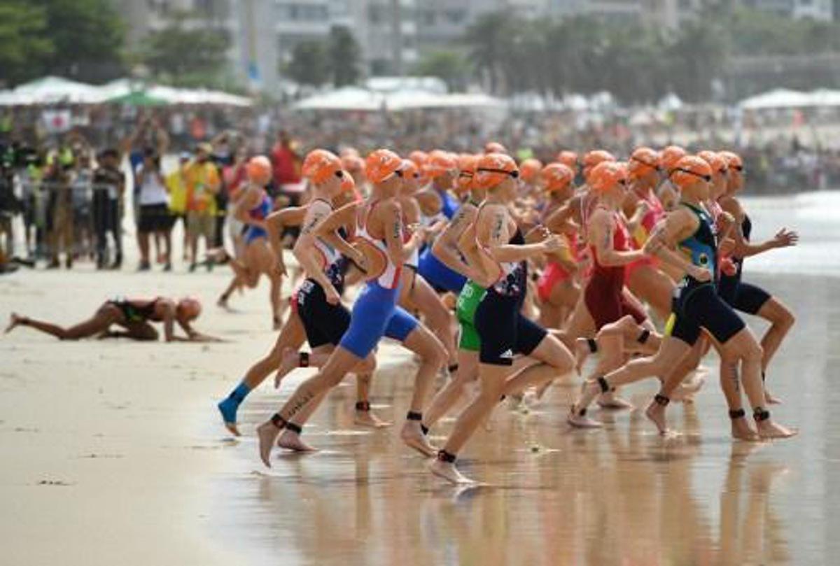 Athletes run into the water for the swimming portion of the women's triathlon, as one competitor (L) falls behind them, at Fort Copacabana during the Rio 2016 Olympic Games in Rio de Janeiro on August 20, 2016.
Leon NEAL / AFP