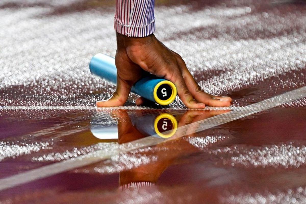 Britain's Efekemo Okoro holds a baton as he competes in the men's 4x400m relay heat during the World Athletics Relays Guangzhou 25 at Guangzhou, in southern China's Guangdong province on May 10, 2025. WANG Zhao / AFP