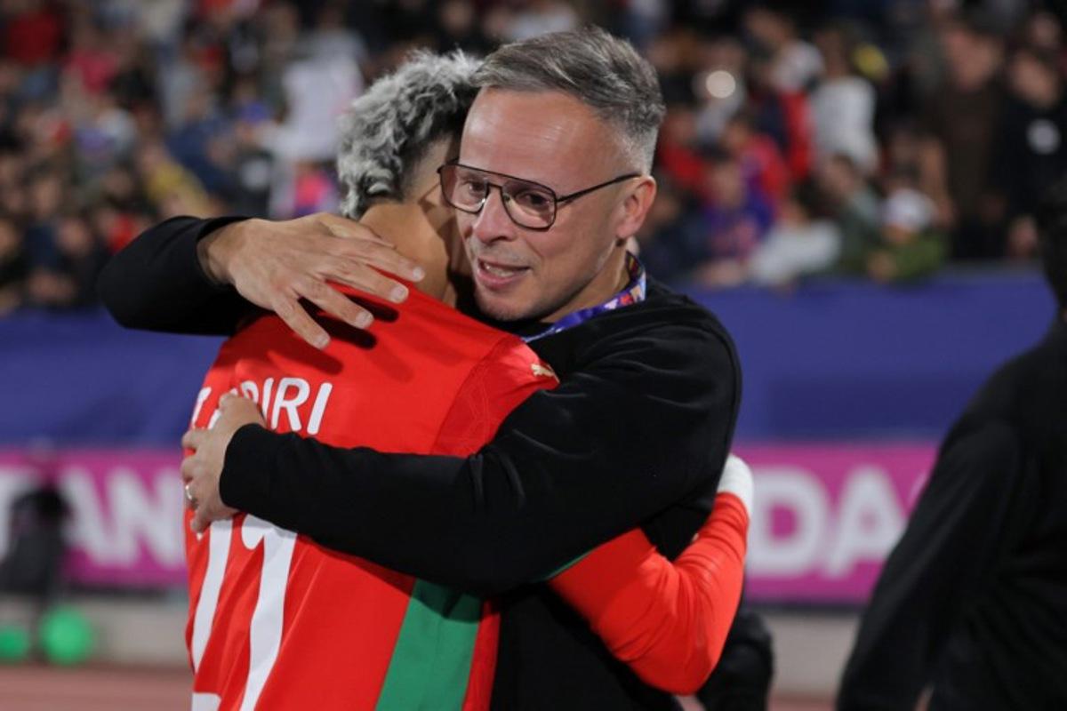 Morocco's head coach Mohamed Ouahbi and forward #21 Yassir Zabiri celebrate after winning the 2025 FIFA U-20 World Cup final football match between Argentina and Morocco at the National Stadium in Santiago on October 19, 2025. Javier TORRES / AFP