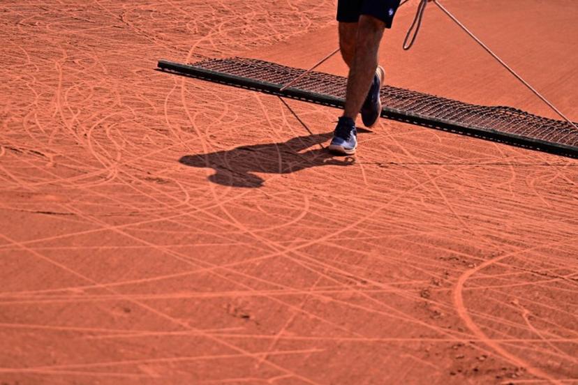 An employee brushes the clay during a wheelchair singles match on day ten of the Roland-Garros Open tennis tournament in Paris on June 6, 2023. JULIEN DE ROSA / AFP
