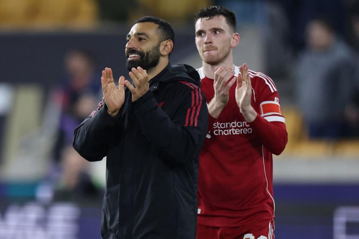 Liverpool's Egyptian striker #11 Mohamed Salah (L) and Liverpool's Scottish defender #26 Andrew Robertson (R) applaud fans on the pitch after the English FA Cup fifth round football match between Wolverhampton Wanderers and Liverpool at the Molineux stadium in Wolverhampton, central England on March 6, 2026. Liverpool won the game 3-1. Darren Staples / AFP