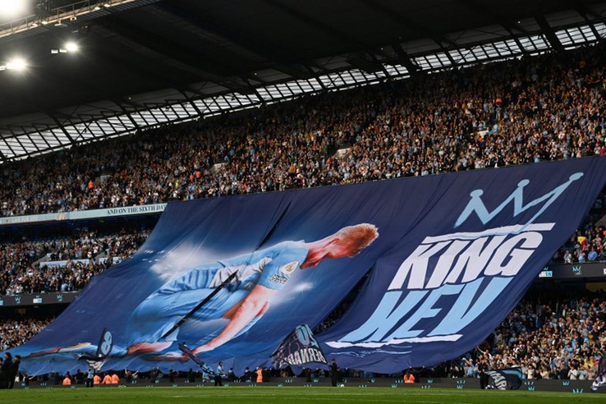 Manchester City supporters wave a banner picturing Manchester City's Belgian midfielder #17 Kevin De Bruyne to celebrate the player last match ahead of vthe English Premier League football match between Manchester City and Bournemouth at the Etihad Stadium in Manchester, north west England, on May 20, 2025. Paul ELLIS / AFP