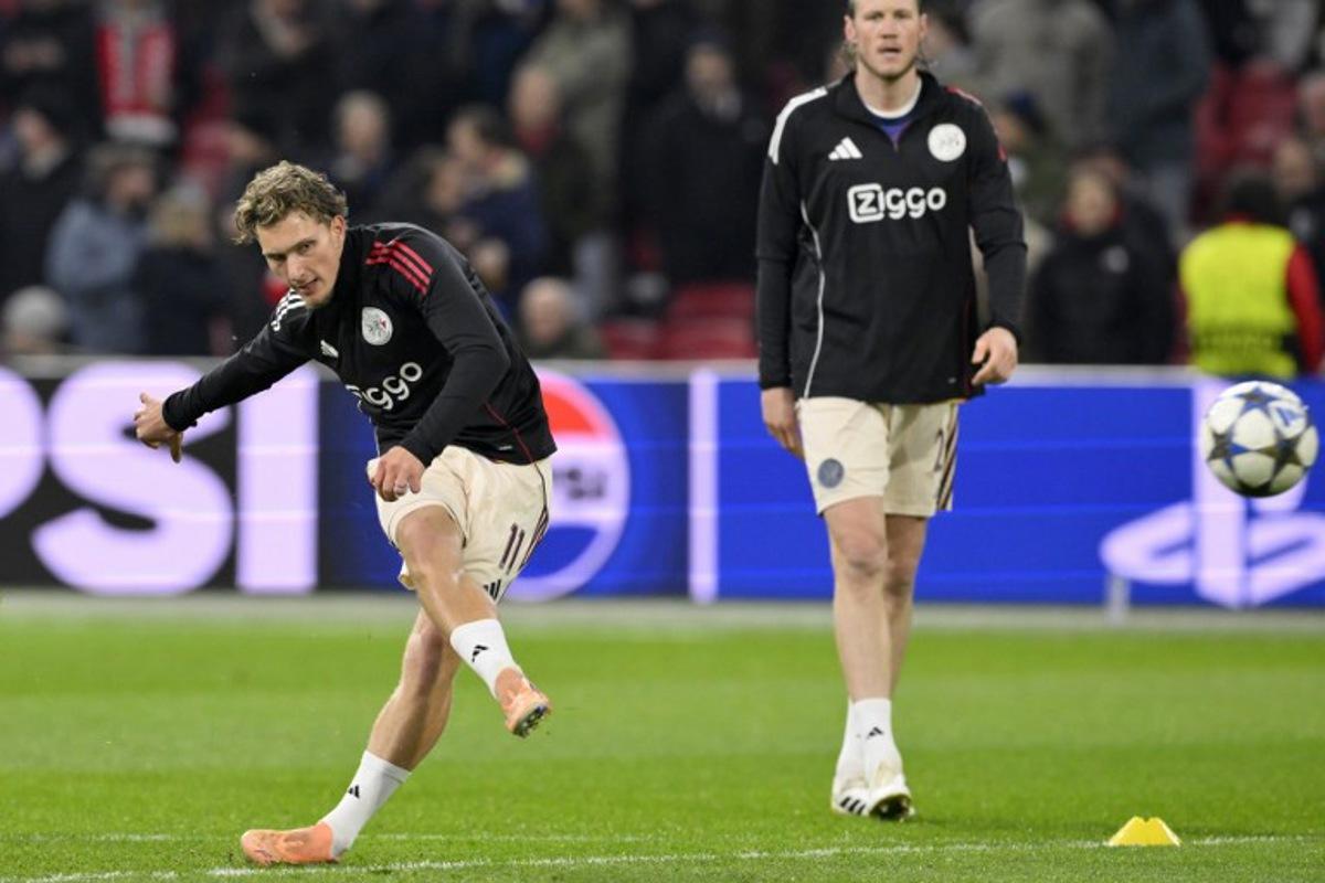 Ajax's Belgian forward #11 Mika Godts (L) warms up prior to the UEFA Champions League, league phase day 5, football match between Ajax and Benfica at the Johan-Cruijff ArenA in Amsterdam on November 25, 2025. JOHN THYS / AFP