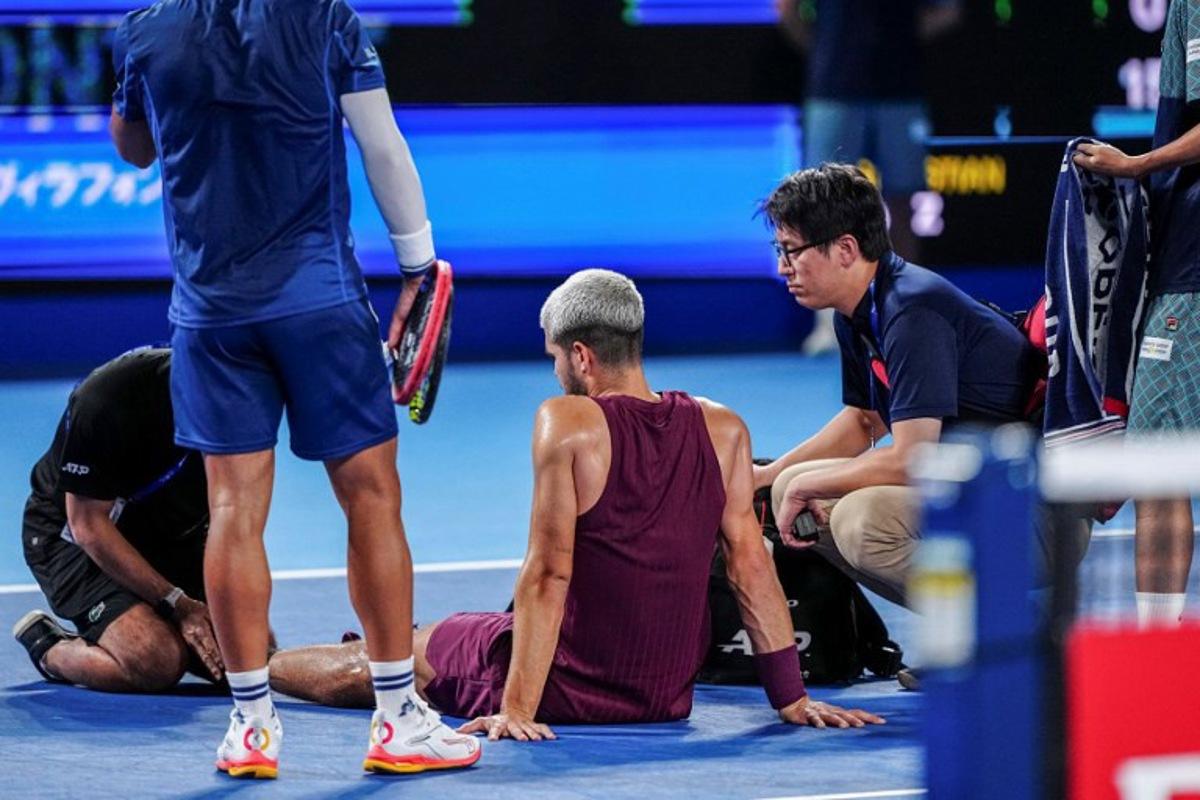 Spain's Carlos Alcaraz gets medical attention during his men's singles round-of-32 match against Argentina's Sebastian Baez at the ATP Japan Open tennis tournament in Tokyo on September 25, 2025. Yuichi YAMAZAKI / AFP