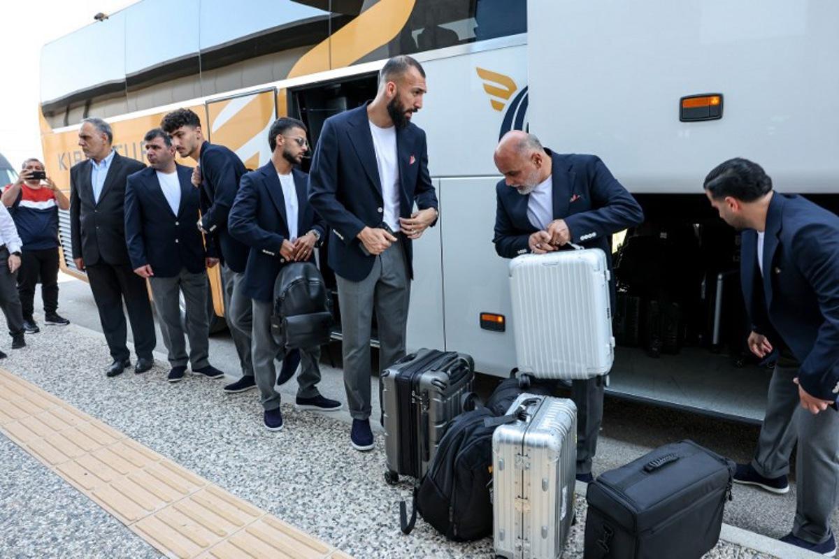 Iran's midfielder #15 Roozbeh Cheshmi (C) and Iran's midfielder #10 Mehdi Ghayedi (C-L) descend from a bus as the Iranian national football team arrives at Antalya Airport for their departure to Mexico ahead of the FIFA 2026 World Cup football tournament, in Antalya, on June 6, 2026. Iran lashed out at the United States on June 6 for refusing visas to some of its World Cup squad support staff as the players were to leave Turkey for Mexico. ONER SAN / AFP