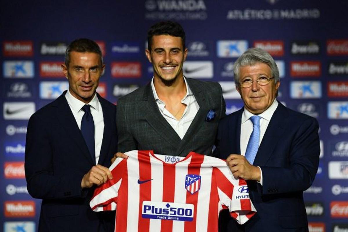 Atletico Madrid's new Spanish defender Mario Hermoso poses with his new jersey next to the Spanish football club's president Enrique Cerezo (R) and sports director Andrea Berta (L) during his official presentation at the Wanda Metropolitano stadium in Madrid on July 18, 2019. GABRIEL BOUYS / AFP