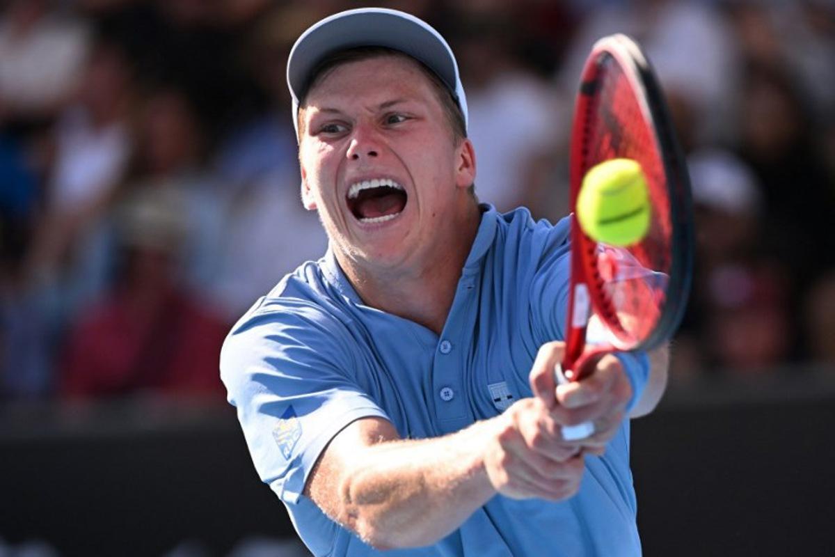 USA's Jenson Brooksby hits a return against USA's Tommy Paul during their men's singles match on day six of the Australian Open tennis tournament in Melbourne on January 21, 2023. WILLIAM WEST / AFP