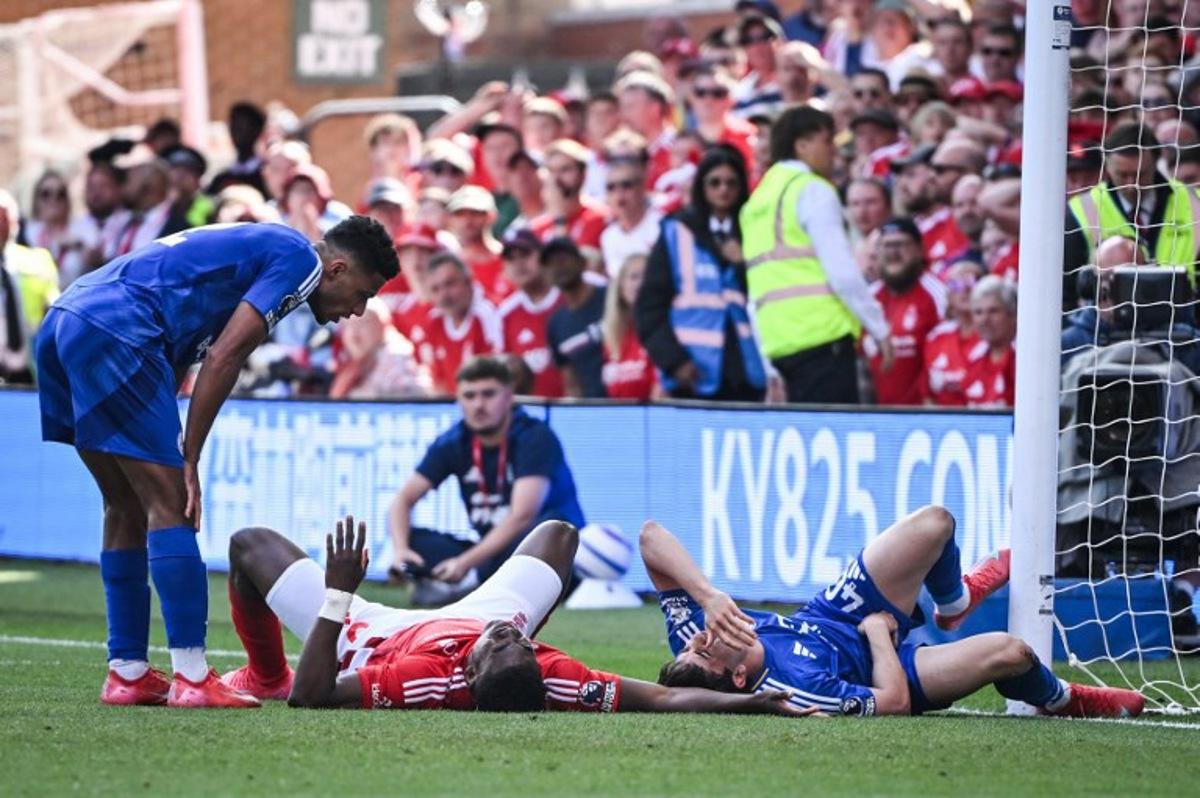 Nottingham Forest's Nigerian striker #09 Taiwo Awoniyi (C) and Leicester City's Argentinian midfielder #40 Facundo Buonanotte (R) react after colliding during the English Premier League football match between Nottingham Forest and Leicester City at The City Ground in Nottingham, central England, on May 11, 2025. JUSTIN TALLIS / AFP