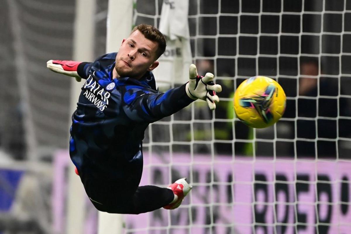Inter Milan's Spanish goalkeeper #13 Josep Martínez attempts to catch the ball as he attends a warm up session prior to the Italian Serie A football match between Inter Milan and Genoa at San Siro stadium in Milan on February 22, 2025. Piero CRUCIATTI / AFP