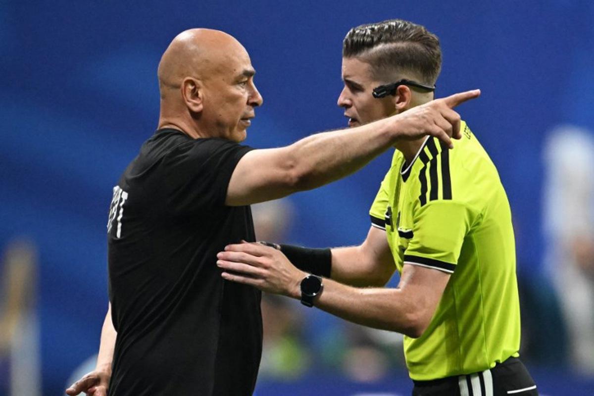 Egypt's head coach Hossam Hassan speaks with French referee Francois Letexier during the 2026 World Cup round of 16 football match between Argentina and Egypt at Atlanta Stadium in Atlanta on July 7, 2026. ROBERTO SCHMIDT / AFP