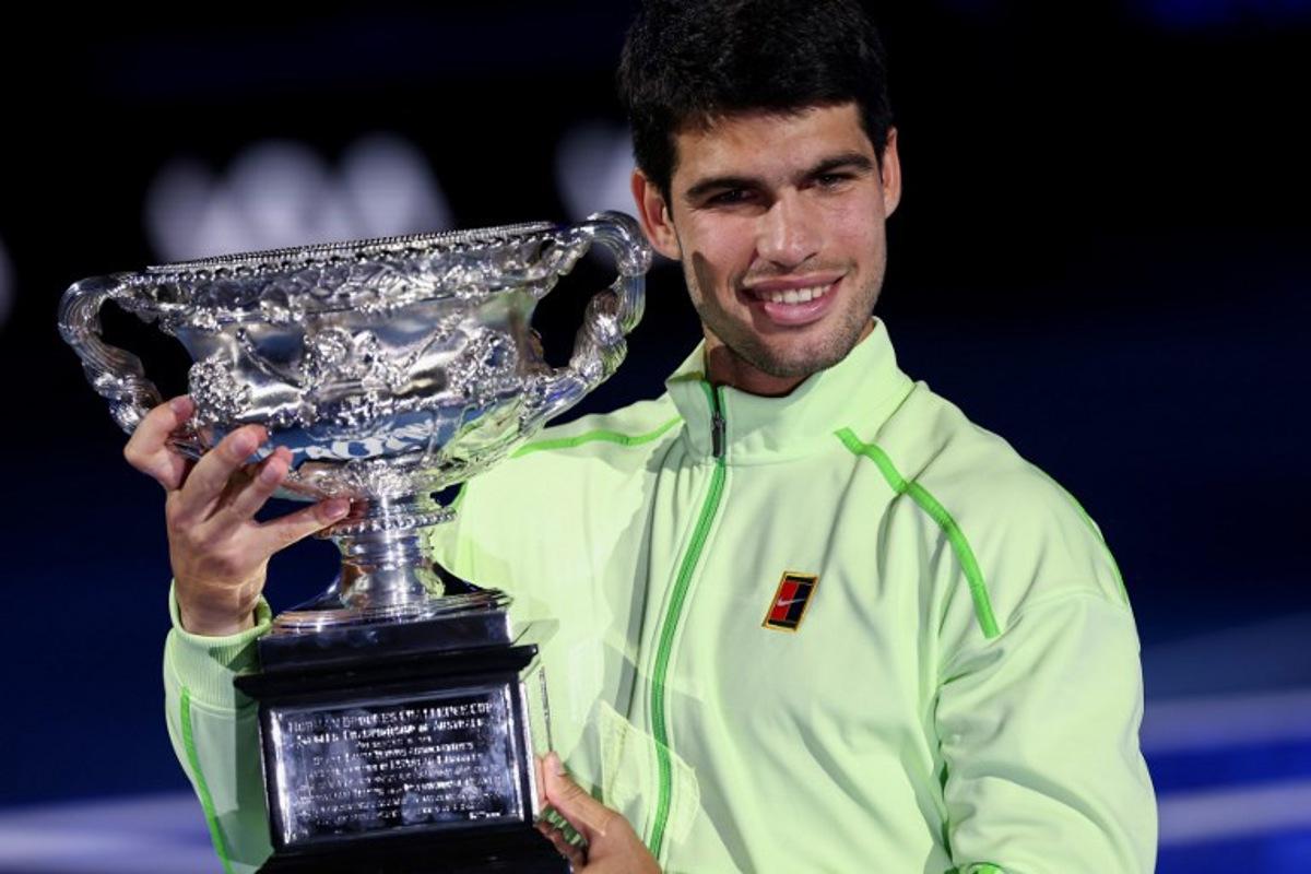 Spain's Carlos Alcaraz poses with the Norman Brookes Challenge Cup after winning against Serbia's Novak Djokovic in their men's singles final match on day fifteen of the Australian Open tennis tournament in Melbourne on February 1, 2026. IZHAR KHAN / AFP