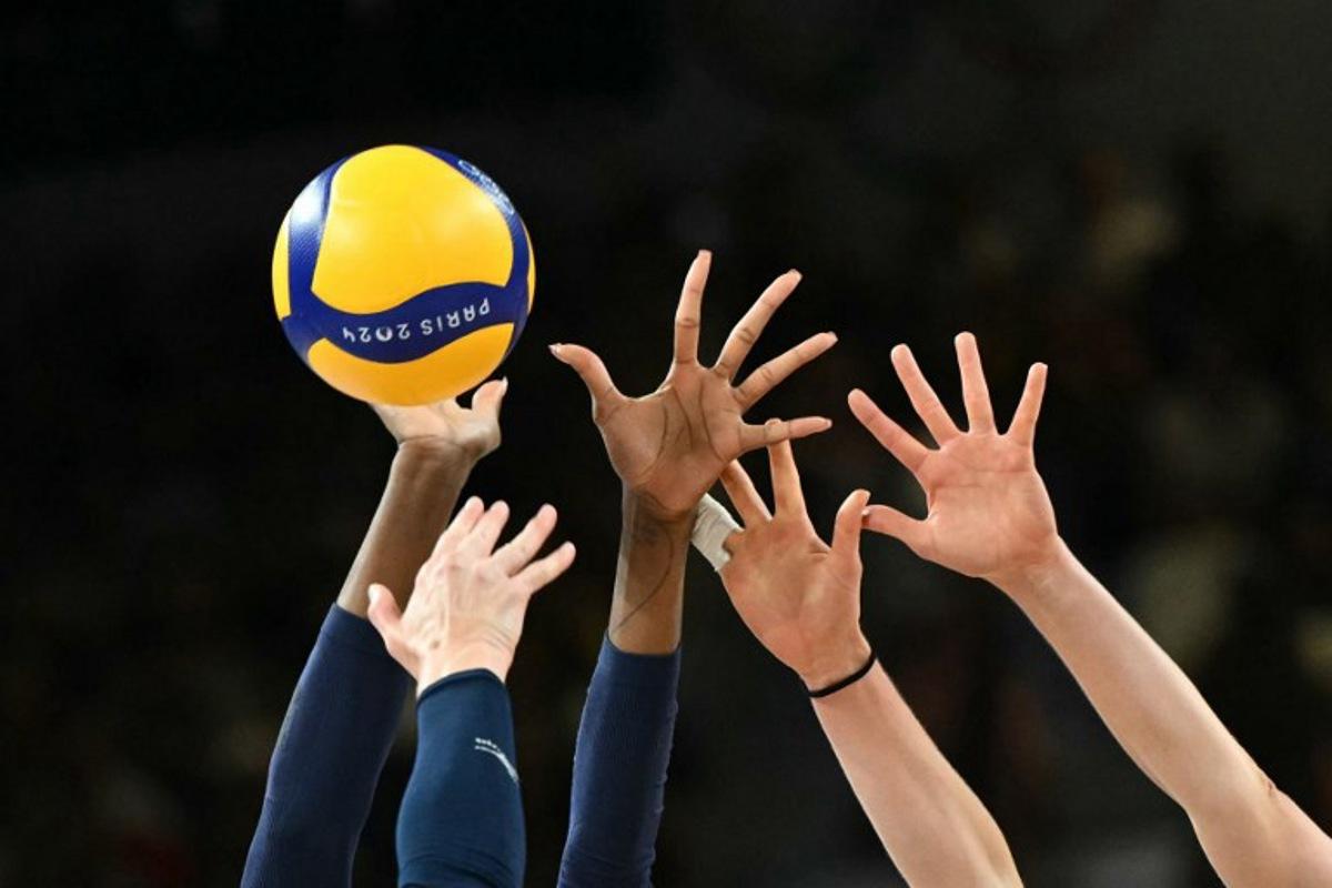 Players jump to hit the ball in the women's volleyball gold medal match between USA and Italy at the South Paris Arena 1 in Paris during the Paris 2024 Olympic Games on August 11, 2024. Natalia KOLESNIKOVA / AFP