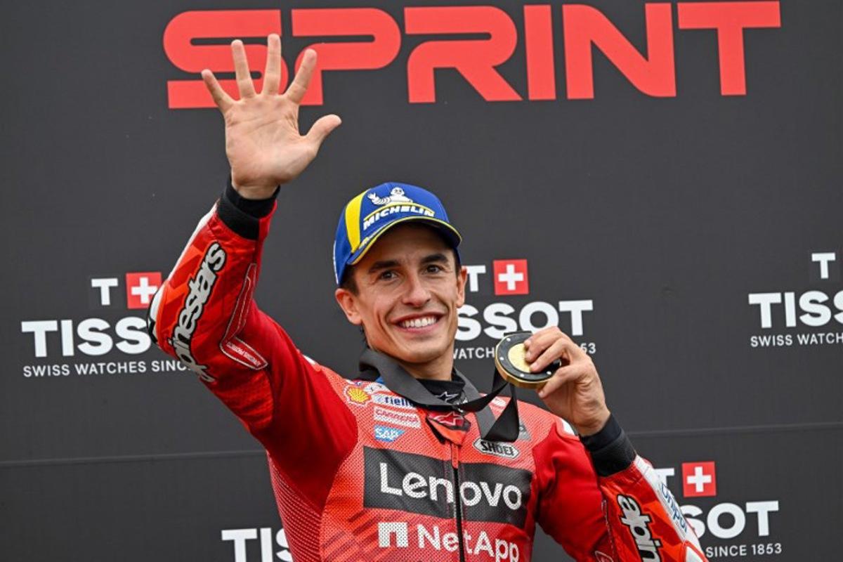 Ducati Lenovo Team's Spanish rider Marc Marquez celebrates his victory with his gold medal after the sprint race ahead of the motorcycle Hungarian Moto GP Grand Prix at the Balaton Park circuit in Balatonfokajar, Hungary, on August 23, 2025. ATTILA KISBENEDEK / AFP