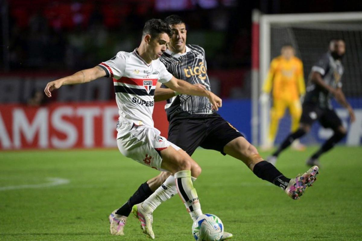 Sao Paulo's midfielder #08 Oscar (L) and Libertad's midfielder #06 Alvaro Campuzano fight for the ball during the Copa Libertadores group stage football match between Brazil's Sao Paulo and Paraguay's Libertad at the Morumbi stadium in Sao Paulo, Brazil, on May 14, 2025. NELSON ALMEIDA / AFP