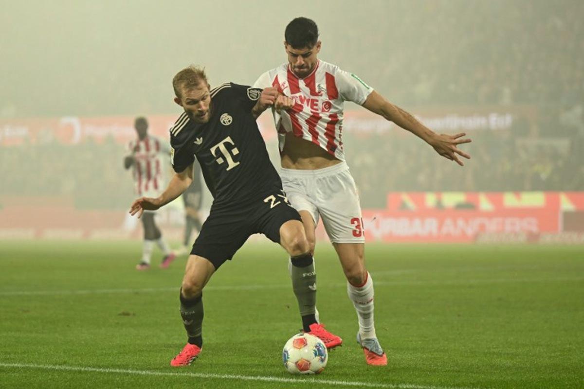 Bayern Munich's Austrian midfielder #27 Konrad Laimer (L) and FC Cologne's Turkish defender #39 Cenk Ozkacar vie for the ball during the German first division Bundesliga football match between FC Cologne and FC Bayern Munich in Cologne, western Germany on January 14, 2026. INA FASSBENDER / AFP