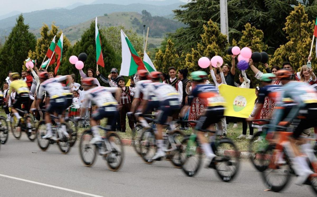 Spectators waving Bulgarian national flags as the pack of rides compete during the 2nd stage of the Giro d'Italia 2026 - Tour of Italy cycling race between Burgas and Veliko Tarnovo, Bulgaria, on May 9, 2026. Luca Bettini / AFP