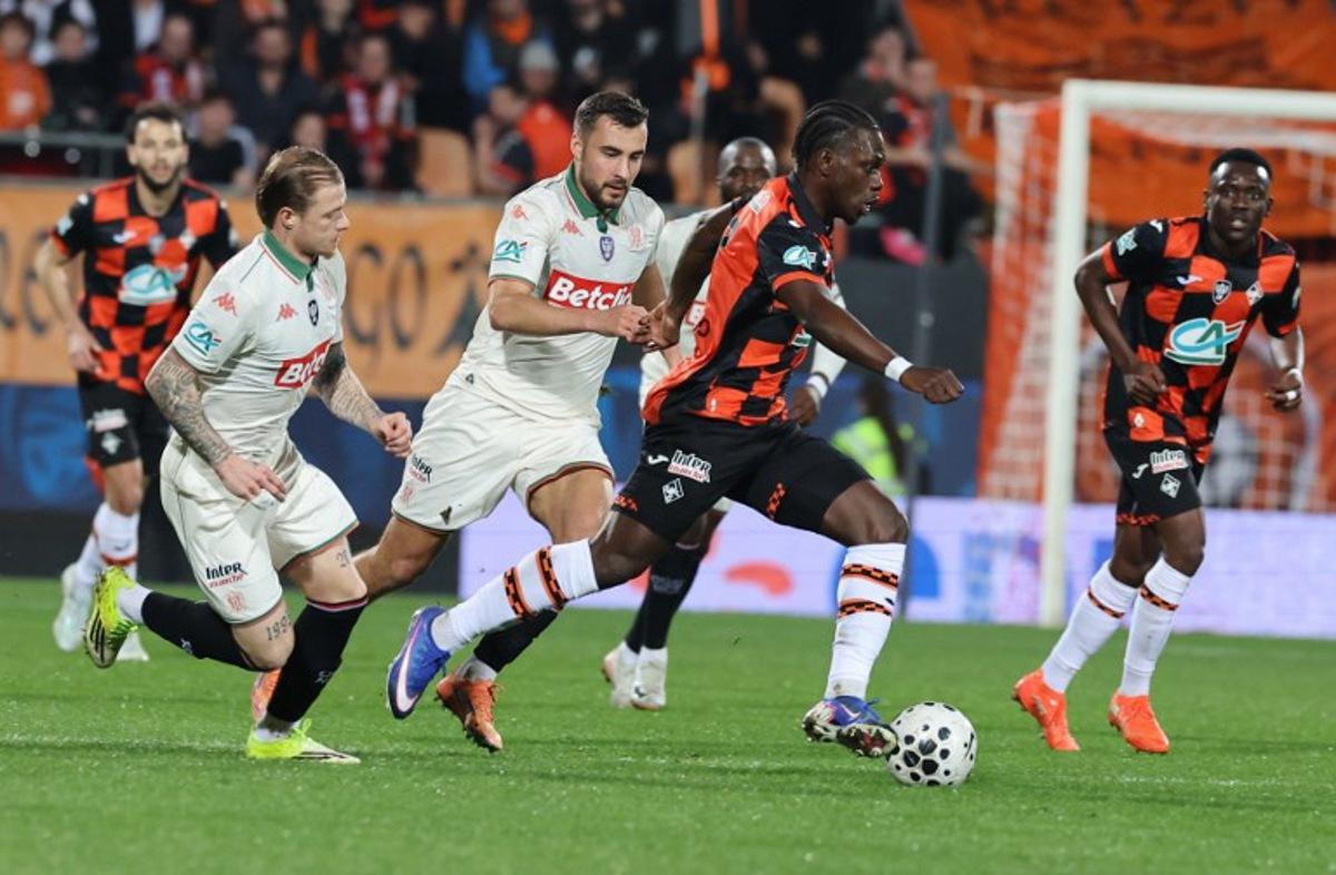 Lorient's French midfielder #17 Jean-Victor Makengo fights for the ball with Nice's Belgian midfielder #24 Charles Vanhoutte and Nice's French defender #26 Melvin Bard during the French Cup quarter final football match between FC Lorient and OGC Nice at the Stade du Moustoir stadium in Lorient, western France on March 4, 2026. Fred TANNEAU / AFP