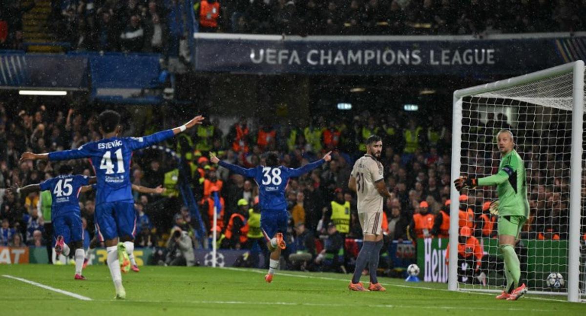 Chelsea's Spanish striker #38 Marc Guiu (C) celebrates scoring the opening goal with team-mates as Ajax's Dutch goalkeeper #22 Remko Pasveer (R) reacts during the UEFA Champions League league-phase football match between Chelsea and Ajax at Stamford Bridge in London on October 22, 2025. Glyn KIRK / AFP