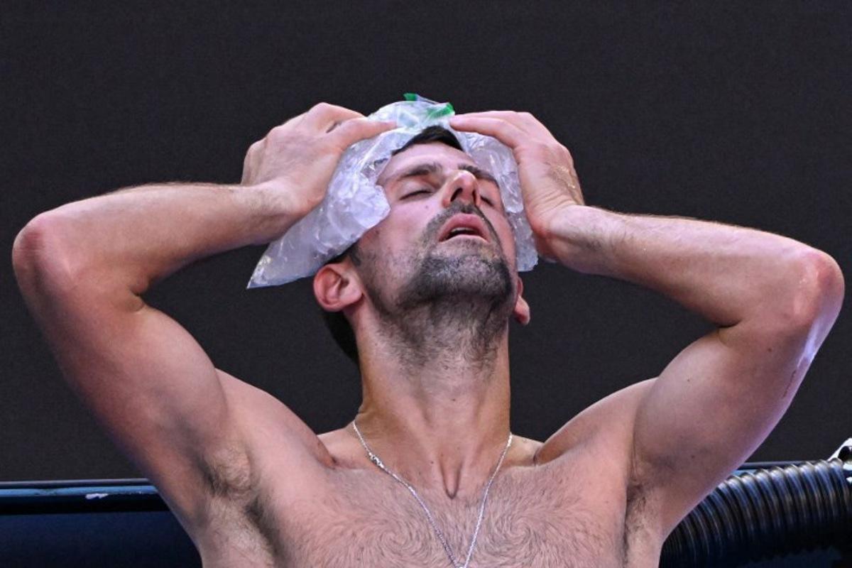 Serbia's Novak Djokovic uses ice packs on his head between the games against USA's Taylor Fritz during their men's singles quarter-final match on day 10 of the Australian Open tennis tournament in Melbourne on January 23, 2024. WILLIAM WEST / AFP
