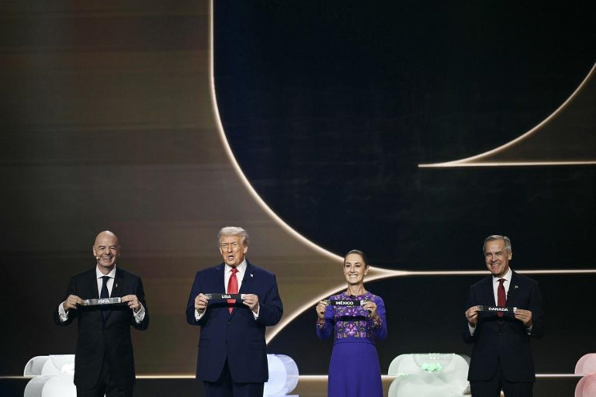 (L-R) FIFA President Gianni Infantino, US President Donald Trump, Mexico's President Claudia Sheinbaum and Canada's Prime Minister Mark Carney hold cards on stage during the draw for the 2026 FIFA Football World Cup taking place in the US, Canada and Mexico, at the Kennedy Center, in Washington, DC, on December 5, 2025. Brendan SMIALOWSKI / AFP