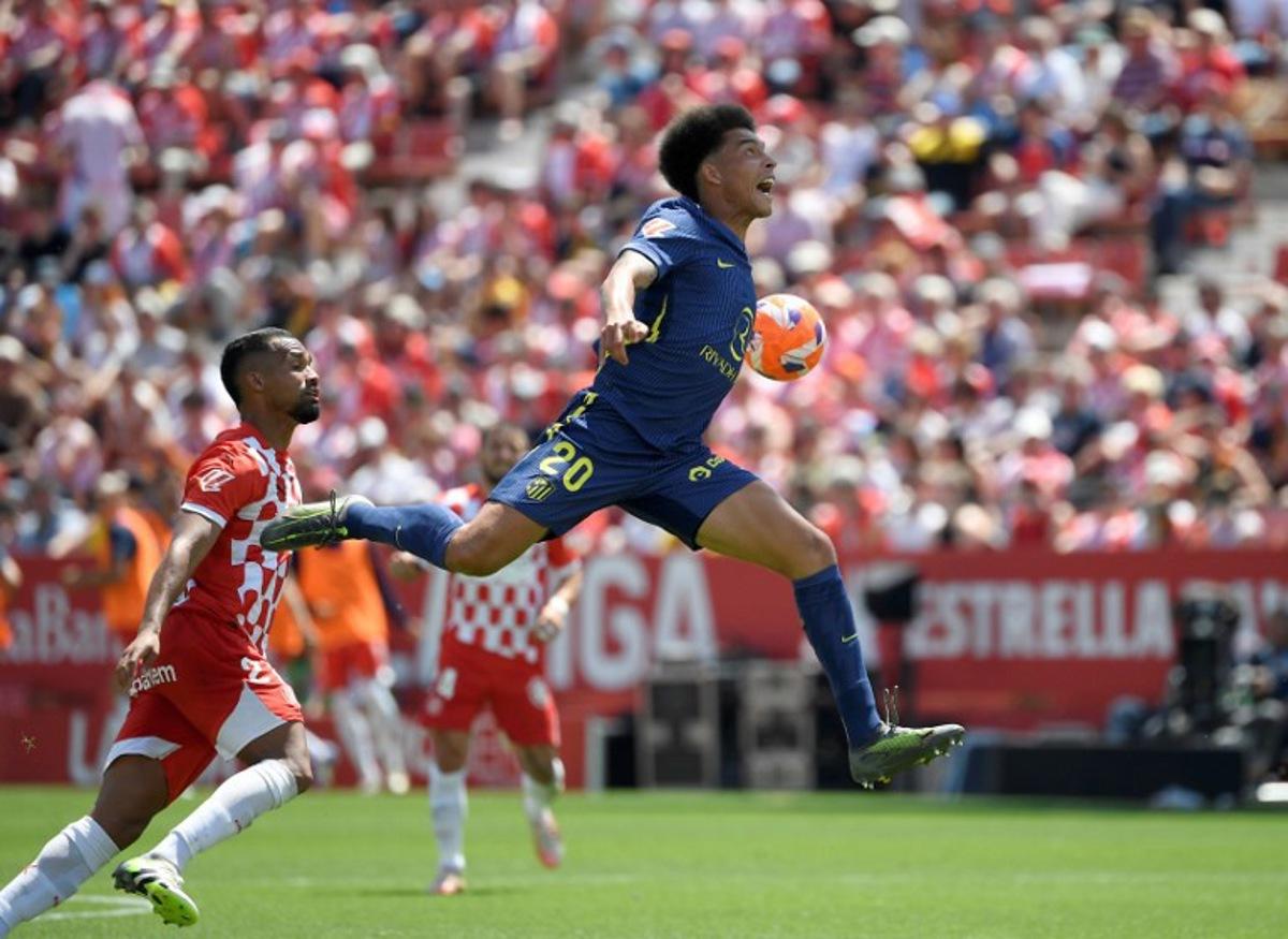 Atletico Madrid's Belgian midfielder #20 Axel Witsel (up) jumps for the ball next to Girona's Venezuelan midfielder #21 Yangel Herrera during the Spanish league football match between Girona FC and Club Atletico de Madrid at Montilivi Stadium in Girona, on May 25, 2025. Josep LAGO / AFP