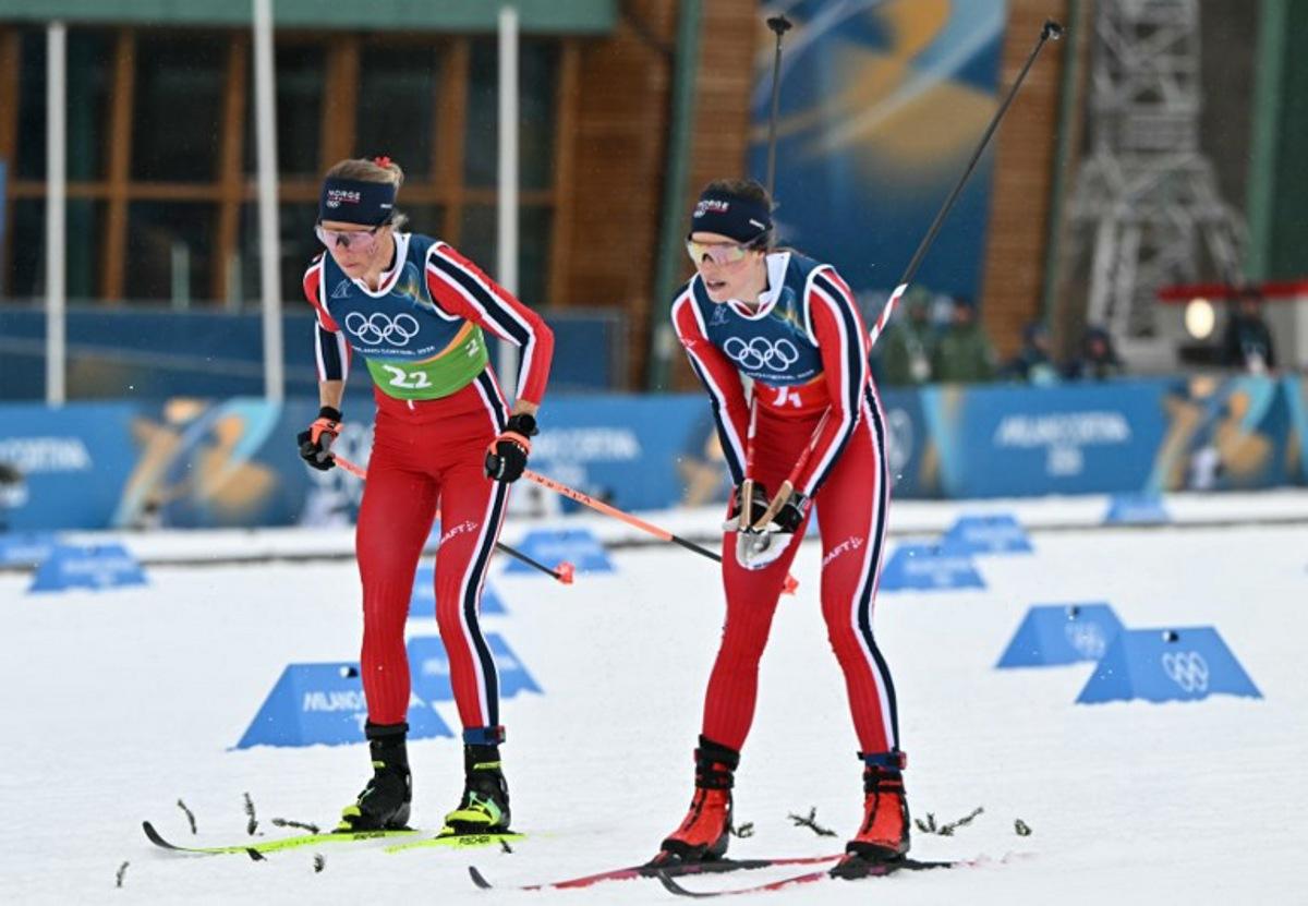 Norway's Kristin Austgulen Fosnaes (R) hands over the relay to Norway's Astrid Oeyre Slind during the cross-country women's 4 x 7,5km relay event of the Milano Cortina 2026 Winter Olympic Games at Tesero Cross-Country Skiing Stadium in Lago di Tesero (Val di Fiemme), on February 14, 2026. Javier SORIANO / AFP