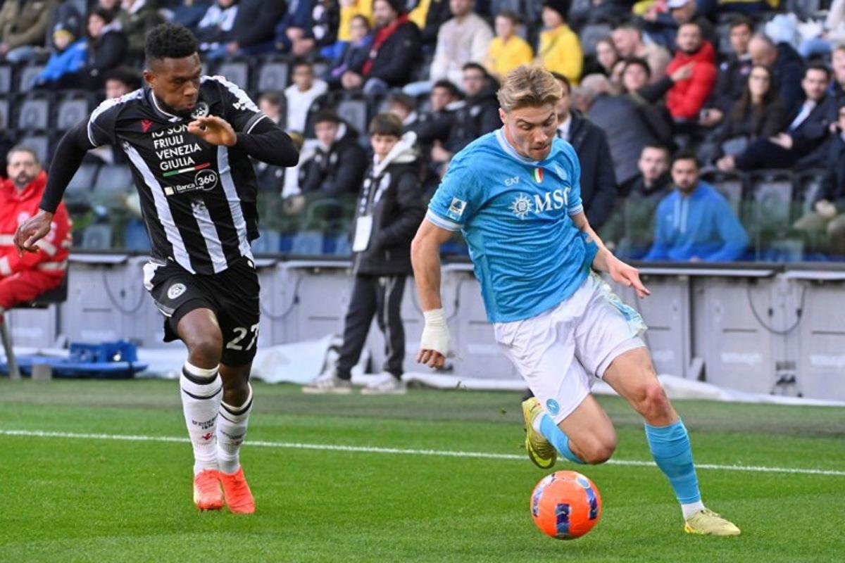 Napoli's Danish forward #19 Rasmus Hojlund controls the ball next to Udinese's Belgian defender #27 Christian Kabasele during the Italian Serie A football match between Udinese and Napoli at the Friuli stadium in Udine on December 14, 2025. ANDREA PATTARO / AFP