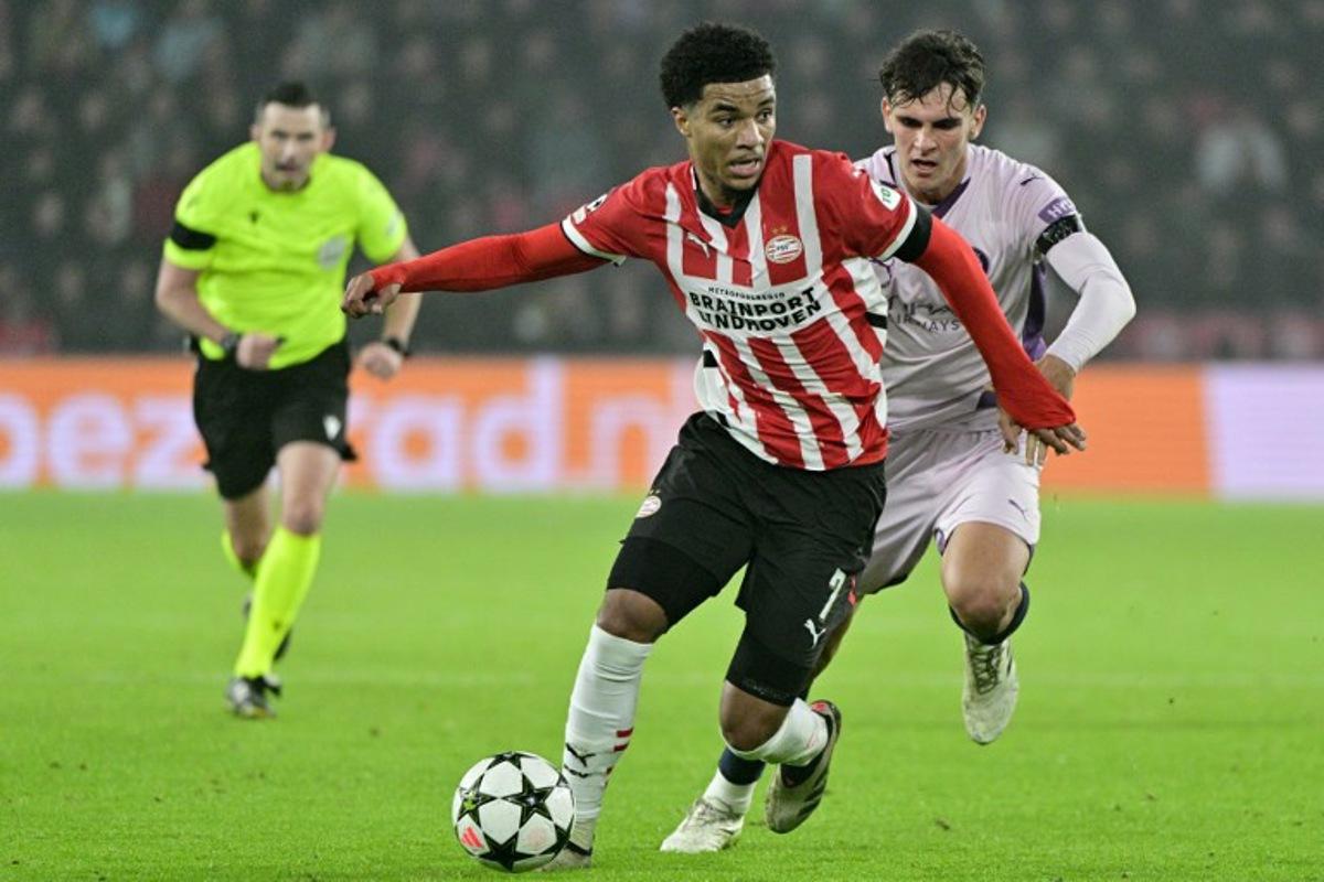 PSV Eindhoven's US midfielder #07 Malik Tillman (C) fights for the ball with Girona's Spanish midfielder #28 Silvi Clua during the UEFA Champions League, League phase - Matchday 4 football match between PSV Eindhoven and Girona FC at the PSV Stadium in Eindhoven on November 5, 2024. Nick Gammon / AFP