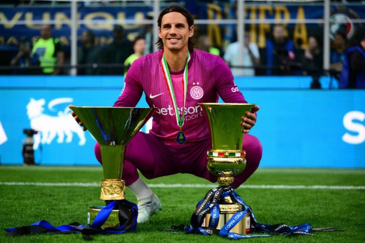 Inter Milan's Swiss goalkeeper #1 Yann Sommer poses with both trophies for the Italian Cup and the 21st scudetto (Italian Championship victory) at San Siro stadium after the Italian Serie A football match between Inter Milan and Hellas Verona in Milan, on May 17, 2026. Marco BERTORELLO / AFP
