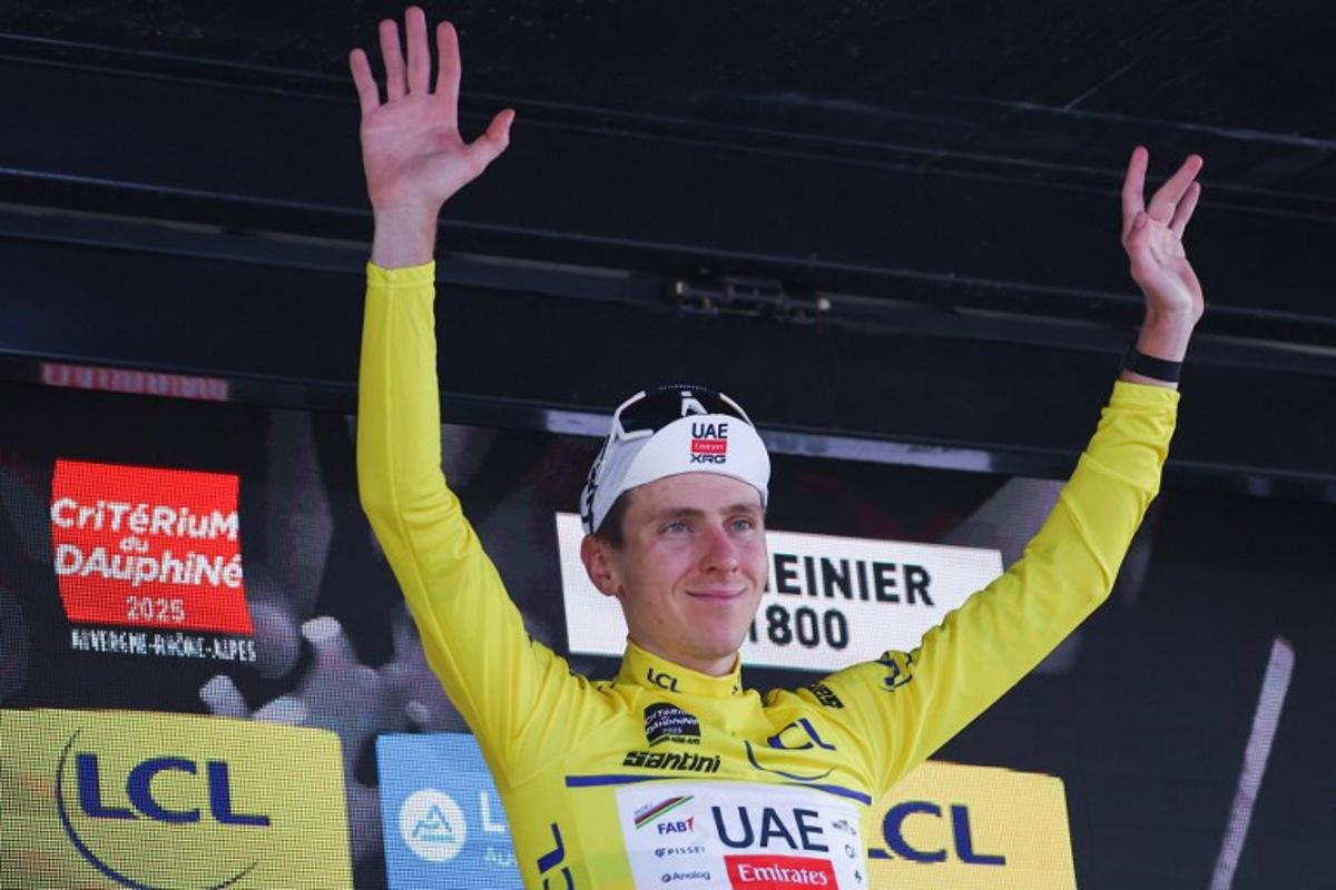 UAE Team Emirates XRG's Slovenian rider Tadej Pogačar celebrates wearing the overall leader's yellow jersey on the podium of the 7th stage of the 77th edition of the Criterium du Dauphine cycling race, 131,6 km between Grand-Aigueblanche and Valmeinier, on June 14, 2025. Anne-Christine POUJOULAT / AFP