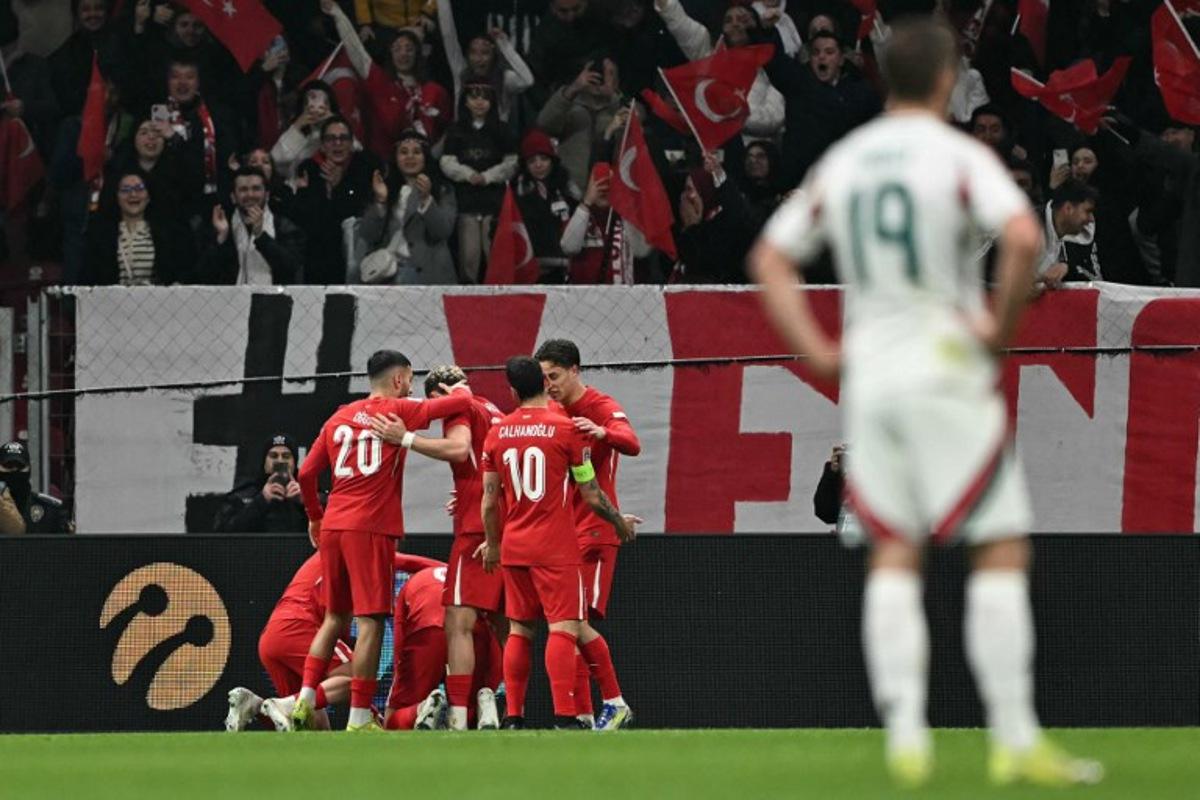Turkey's midfielder #06 Orkun Kokcu celebrates with teammates after scoring his team's first goal during the UEFA Nations League playoff first-leg football match between Turkey and Hungary at the Rams Park Ali Samiyen Sport Complex Stadium in Istanbul on March 20, 2025. OZAN KOSE / AFP
